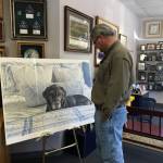 Mac the Black Lab's owner looking at the painting